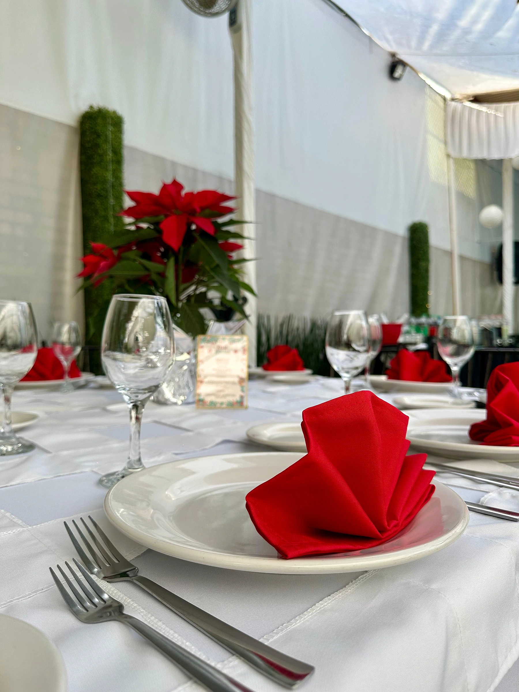Mesa con servilletas rojas y centro de nochebuenas