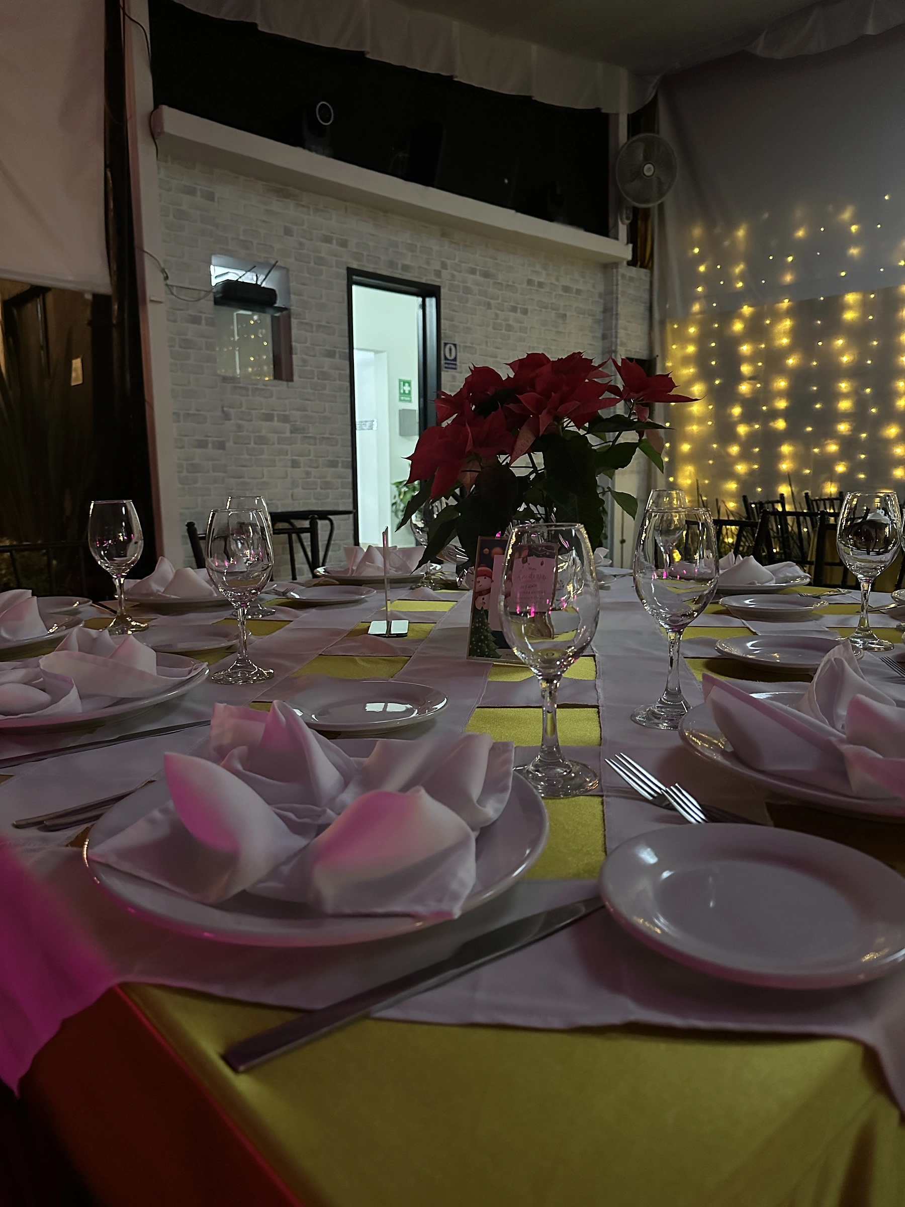Mesa con camino dorado, nochebuenas y cortina de luces